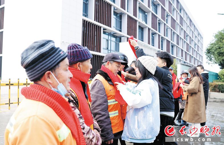 　　1月3日，来自湖南工艺美术职业学院的大学生给环卫工人戴上亲手编织的围巾。 长沙晚报通讯员 盛磊 全媒体记者 石祯专 摄影报道